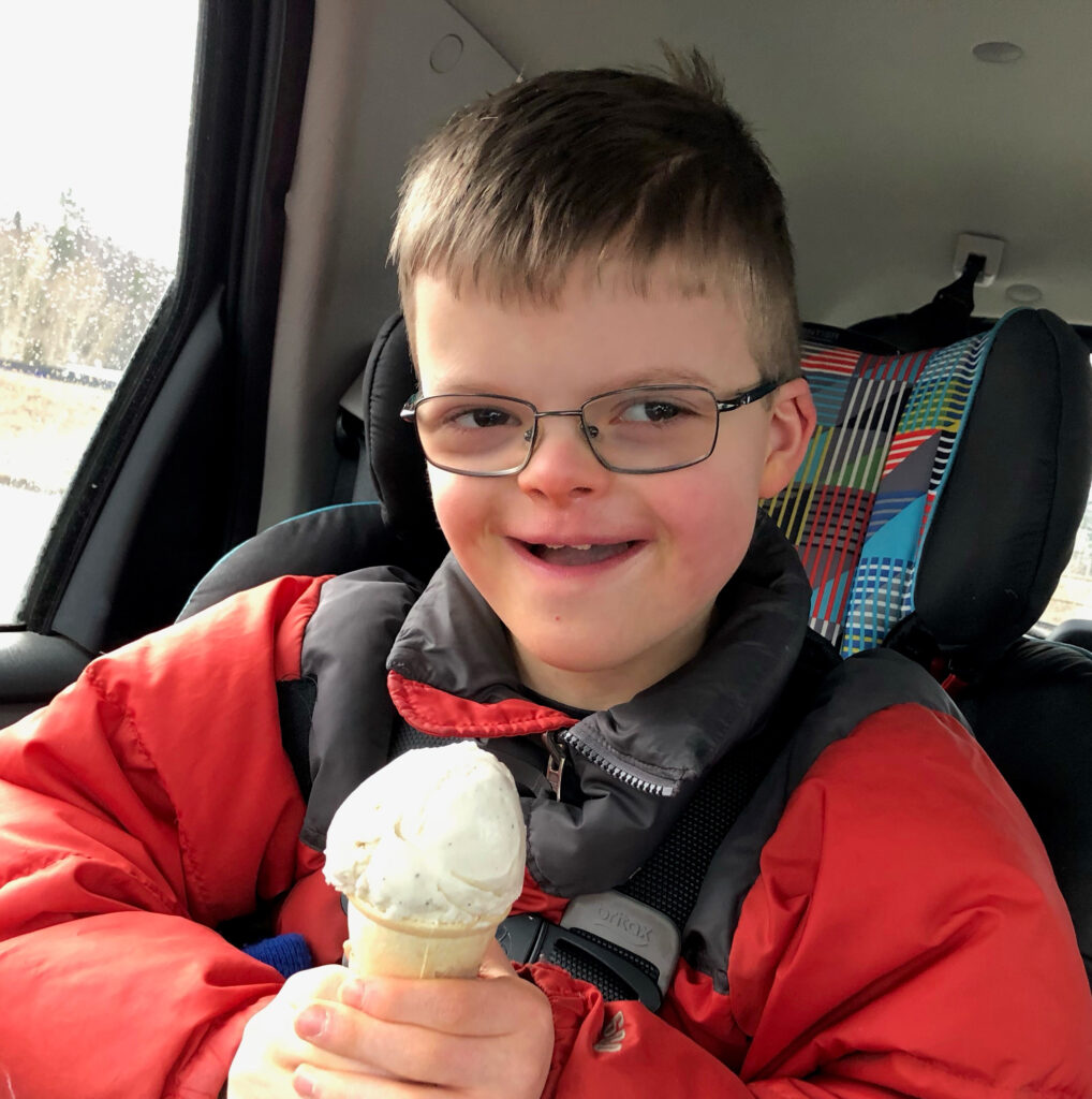 child holding an ice cream cone sitting in a car