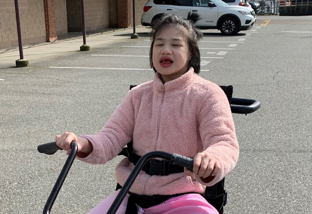 Child riding an adaptive tricycle